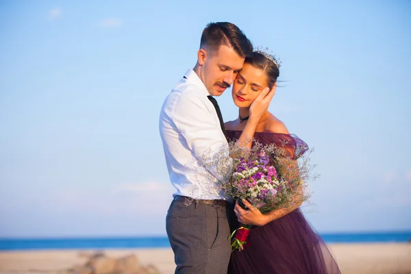 Jeune couple romantique se détendre sur la plage en regardant le coucher du soleil — Photo