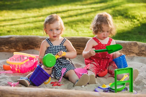 Las dos niñas jugando juguetes en la arena — Foto de Stock