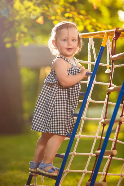 A menina brincando no playground ao ar livre — Fotografia de Stock