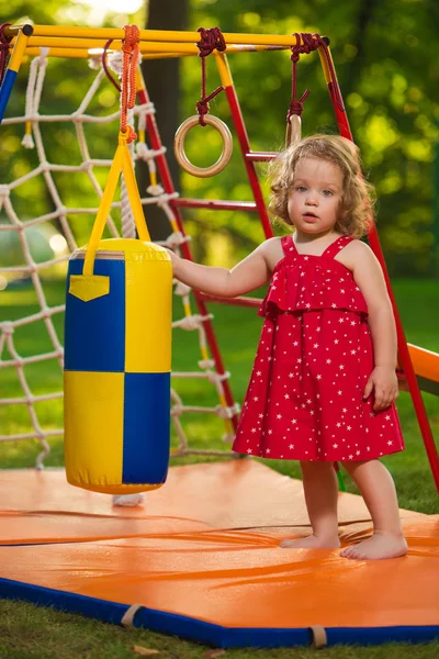 A menina brincando no playground ao ar livre — Fotografia de Stock