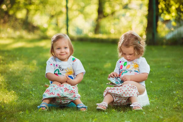 As duas meninas pequenas sentadas em panelas — Fotografia de Stock