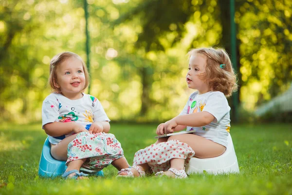 Las dos niñitas sentadas en macetas — Foto de Stock