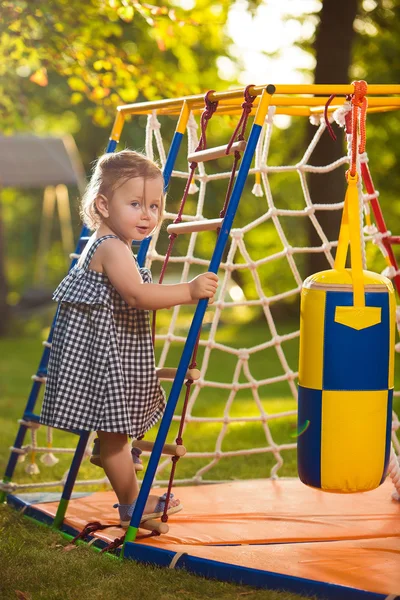 La pequeña niña jugando en el patio al aire libre — Foto de Stock