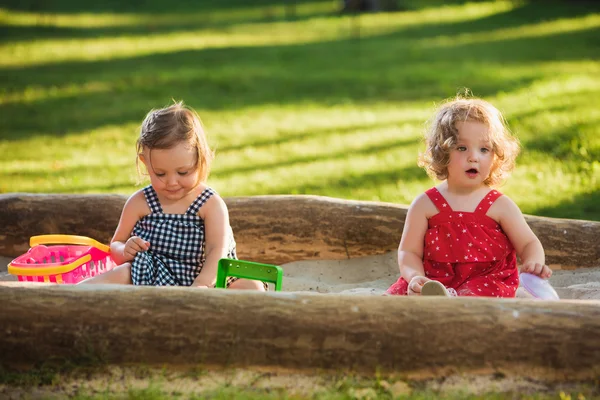 Las dos niñas jugando juguetes en la arena — Foto de Stock