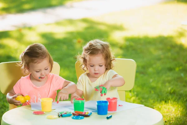 Dos años de edad, las niñas pintando con pinturas de póster juntos contra el césped verde — Foto de Stock
