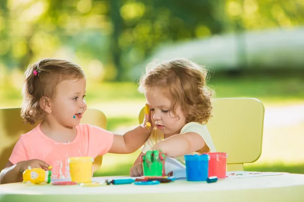 Dos años de edad, las niñas pintando con pinturas de póster juntos contra el césped verde — Foto de Stock