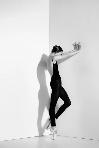 Ballerina in abito nero in posa su scarpe da punta, sfondo studio . — Foto Stock