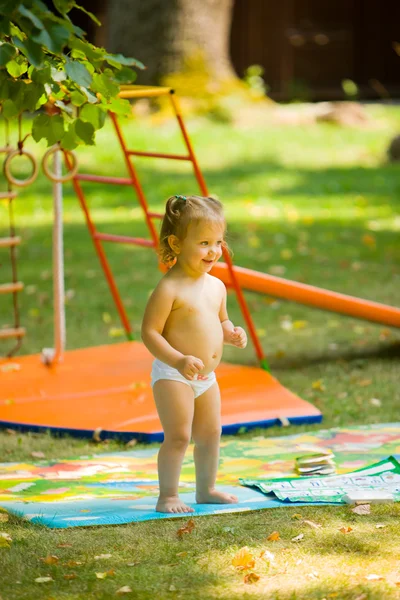 La petite fille jouant à l'aire de jeux extérieure — Photo