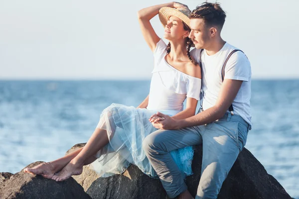 Glad ung romantiska par koppla av på stranden och titta på solnedgången — Stockfoto