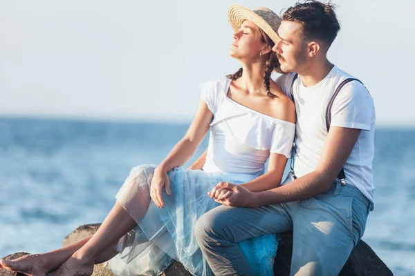 Joyeux jeune couple romantique se détendre sur la plage et regarder le coucher du soleil — Photo