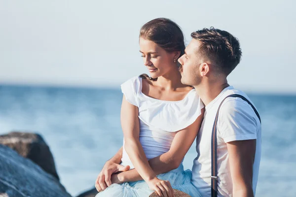 Feliz pareja romántica joven relajándose en la playa y viendo la puesta de sol —  Fotos de Stock