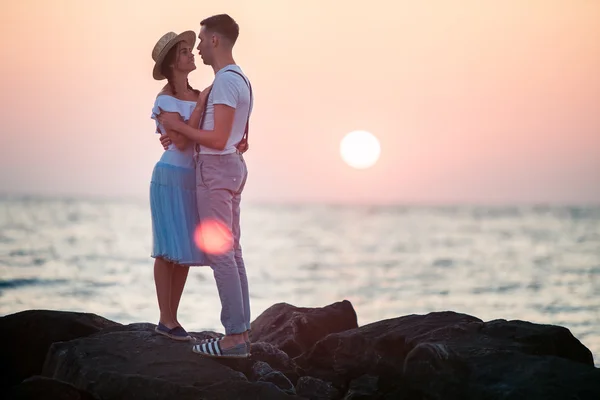 Boldog fiatal szerelmespár pihennek a tengerparton, és figyelte a naplemente — Stock Fotó