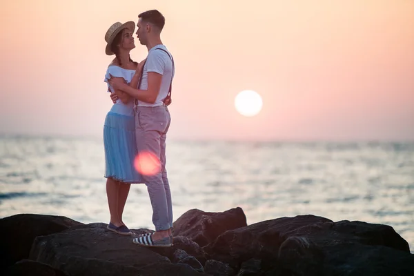 Glückliches junges romantisches Paar entspannt am Strand und beobachtet den Sonnenuntergang — Stockfoto