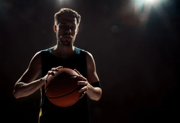 Weergave van het silhouet van een basketbalspeler houdt van basketbal op zwarte achtergrond — Stockfoto