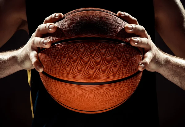 Προβολή σιλουέτα ενός παίκτη μπάσκετ κρατώντας μπάλα μπάσκετ σε μαύρο φόντο — Φωτογραφία Αρχείου