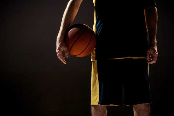 Tampilan siluet dari pemain basket memegang bola basket pada latar belakang hitam — Stok Foto