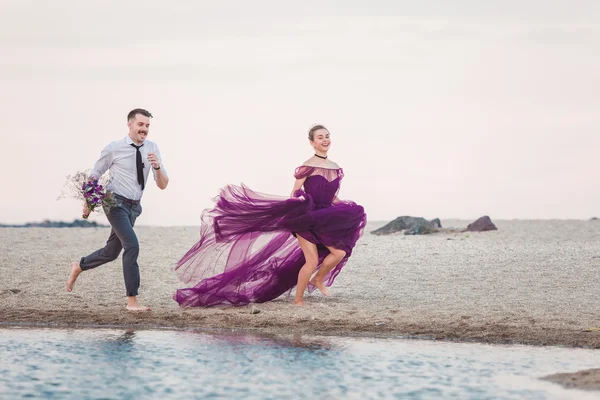 Junges romantisches Paar läuft am Strand des Meeres — Stockfoto