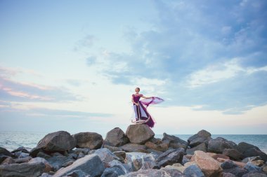 Young romantic woman posing on the beach watching the sunset