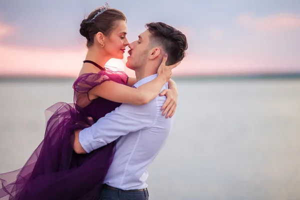 Pareja romántica joven relajándose en la playa viendo el atardecer — Foto de Stock