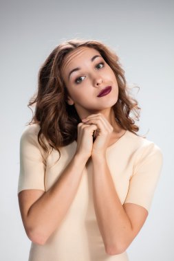 Kadın gri arka plan üzerinde yalvaran arıyor