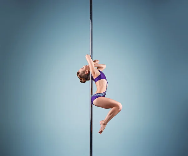 Het sterke en gracieuze jonge meisje uitvoeren van acrobatische oefeningen op een pylon — Stockfoto