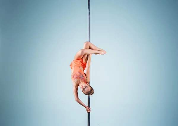 Den starka och graciösa ung flicka utför akrobatiska övningar på pylon — Stockfoto