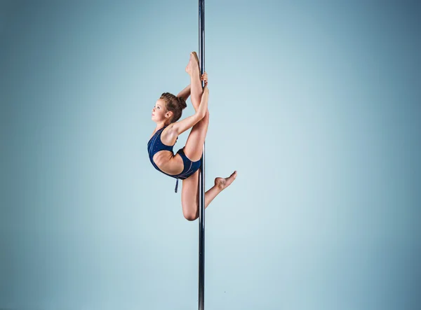 Mocne i pełne wdzięku dziewczyna wykonywania ćwiczeń akrobatycznych na pylon — Zdjęcie stockowe
