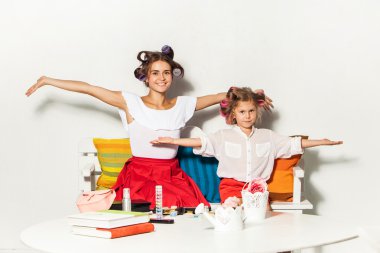 Annesiyle birlikte oturan ve oynarken küçük kız