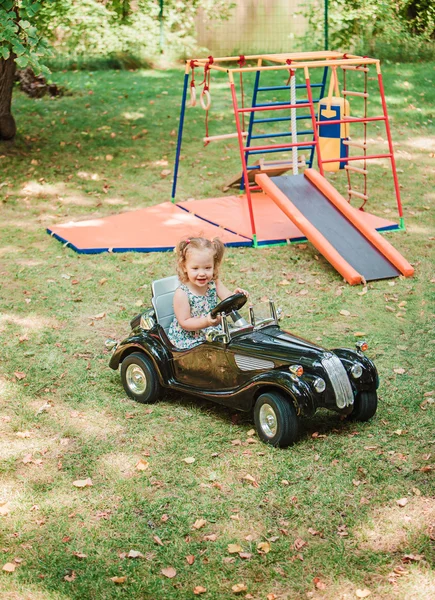 A pequena menina brincando no carro — Fotografia de Stock