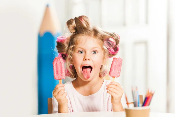 Маленькая девочка сидит и ест мороженое — стоковое фото