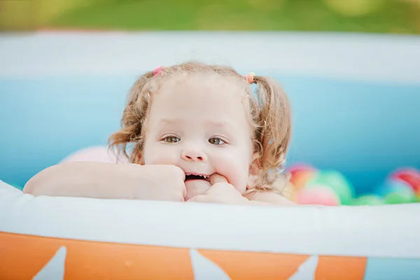 Yaz güneşli bir günde şişme havuz oyuncakları ile oynarken küçük bebek kız — Stok fotoğraf