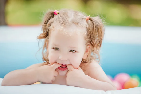 Het babymeisje, spelen met speelgoed in opblaasbaar zwembad in het zonnige zomerdag — Stockfoto