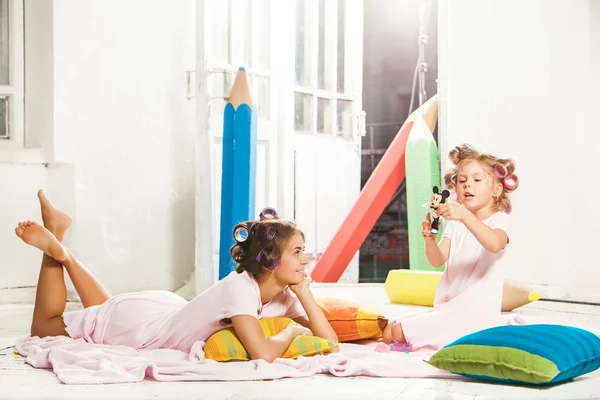 Petite fille assise avec sa mère et jouant — Photo