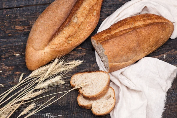 Du pain rustique sur une table en bois. Fond en bois foncé — Photo