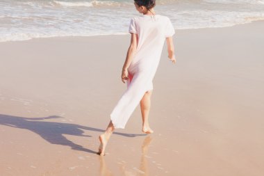 Kumsalda yürüyen kadın bacakları.