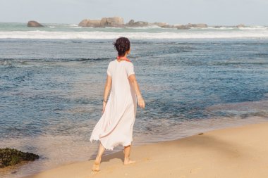 Plaj kum üzerinde yürüyen kadın