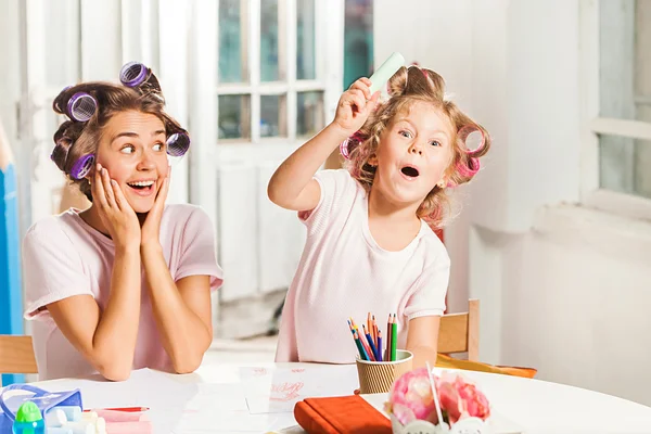 A jovem mãe e sua filhinha desenhando com lápis em casa — Fotografia de Stock