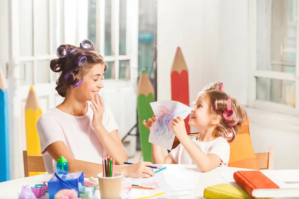La giovane madre e la sua figlioletta disegnano con le matite a casa — Foto Stock