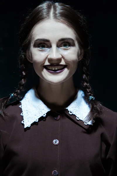 Portrait of a young smiling girl in school uniform as killer woman — Stock Photo, Image