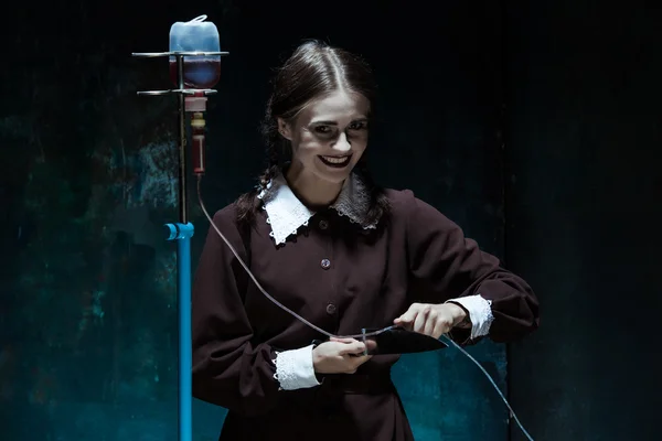 Retrato de uma jovem no uniforme da escola como mulher assassina — Fotografia de Stock