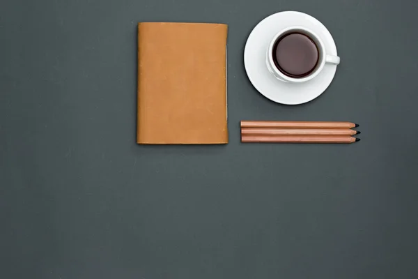 Table de bureau avec crayons, cahier et une tasse de café — Photo