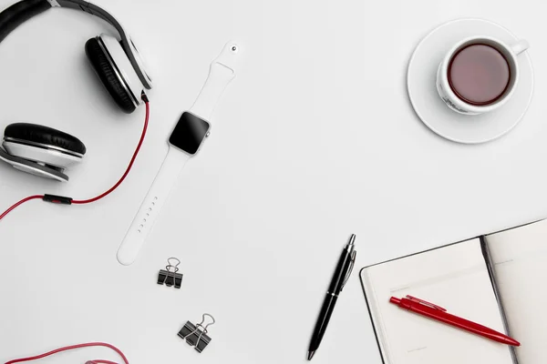 Чашка, ручка та навушники на білому тлі — стокове фото