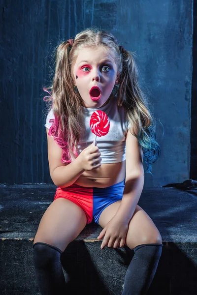 A garota engraçada com doces no fundo escuro — Fotografia de Stock