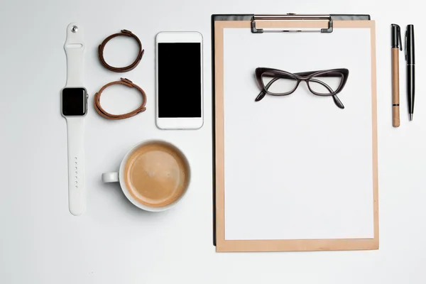 Office desk table with cup, supplies, phone on white — Stock Photo, Image