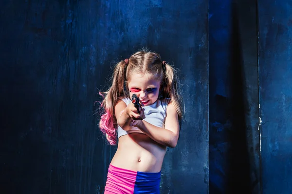 Little girl pointing in toy gun