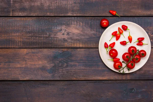 Les tomates cerises, les poivrons, le piment sur la table en bois — Photo