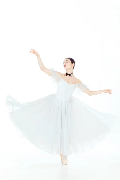 Ballerine en robe blanche posant sur pointes, fond studio . — Photo