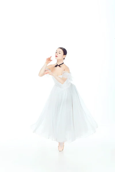 Ballerina im weißen Kleid posiert auf Spitzenschuhen, Studiohintergrund. — Stockfoto