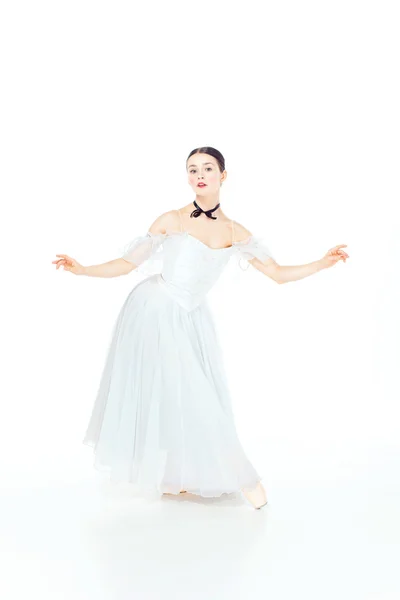 Baletka v bílých šatech pózuje na pointe boty, studio pozadí. — Stock fotografie