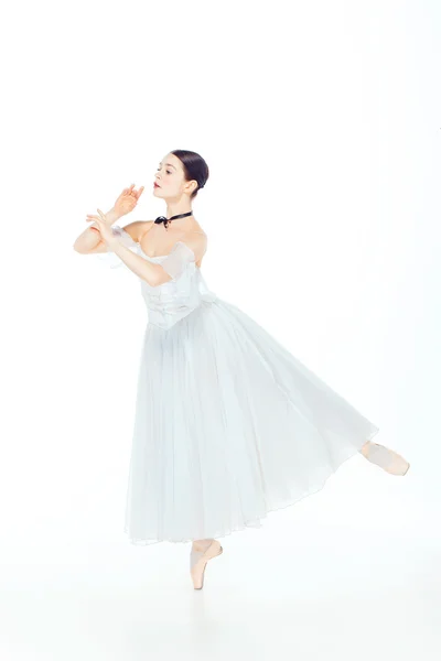 Балерина в белом платье позирует на пуантах, студийный фон . — стоковое фото